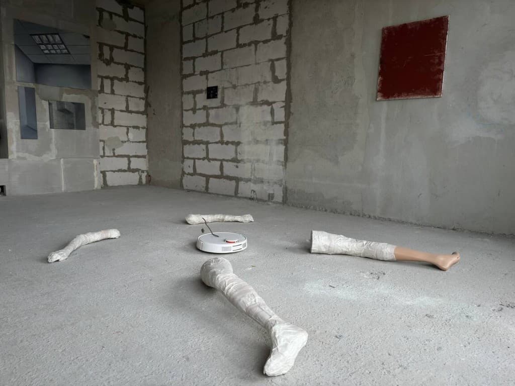 zapoishche — installation view with robot vacuum and wrapped legs